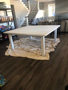 a table is being installed in the middle of a room that has been painted white