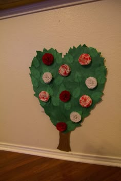 a paper heart shaped tree with red, white and pink flowers on it's leaves