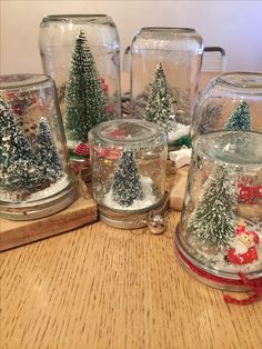 snow globes with christmas trees in them on a table