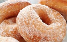 several sugared donuts piled on top of each other in front of the camera