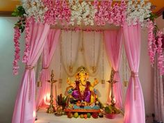 a decorated stage with pink drapes and flowers