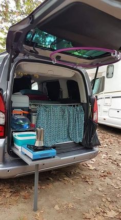 the back end of a van with its trunk open and various items in it sitting on the ground