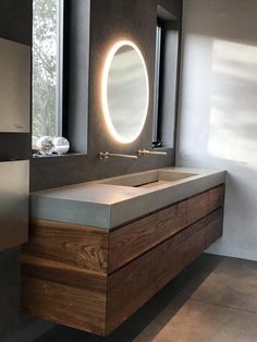 a bathroom with a sink, mirror and lights on the side of the wall in front of it