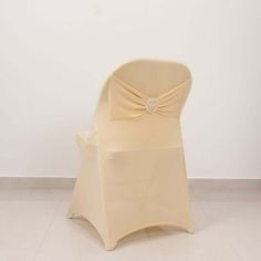 a chair with a bow on it sitting in front of a white wall and tile floor