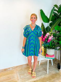 This playful mini dress combines blue and green in a charming chevron and stripe pattern, complete with a front panel and tiered ruffle seams. The ruffle sleeves and V-neckline add a touch of flirtiness, perfect for showing off your favorite necklaces. Whether you're heading to a weekend brunch or an outdoor concert, this dress has the perfect length for all heights. Style it with strappy sandals and a wide-brim hat for a chic, summery look! PRODUCT FIT - TRUE TO SIZE MODEL DETAILS - BRENNA IS A Green Ruffle Sleeve Mini Dress For Spring, Green Mini Dress With Ruffle Sleeves For Spring, Green Tiered Ruffle Dress For Beach, Green Ruffle Sleeve Dress For Beach, Green Mini Dress With Ruffle Hem And Sleeves, Chic Green Mini Dress With Ruffle Sleeves, Green Summer Tiered Dress, Green Summer Tiered Beach Dress, Green Tiered Mini Dress For Brunch