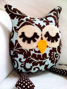 an owl pillow sitting on top of a white couch