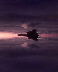 a fighter jet flying through a cloudy sky