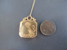 "I'm always asked for jewels with lions. Here's a fantastic antique locket with a lion holding a shield on the front of the piece. This 18k yellow gold square locket opens to reveal the original double sided beveled glass; you can place a photo on either side. This is a great antique piece so snag it before it's gone! Very good antique condition. Locket closes well and securely! There are dents on the front/back/sides as seen in the photos. This is a pre-worn antique. The original beveled glass Gold Jewelry With Coat Of Arms In 14k Gold, Antique Coat Of Arms Jewelry For Formal Occasions, Antique Engraved Square Pendant Jewelry, Heirloom Yellow Gold Coat Of Arms Jewelry, Antique Bronze Rectangular Jewelry, Antique Rectangular Bronze Jewelry, Rectangular Vintage Charm Jewelry For Formal Occasions, Antique Square Locket Pendant Jewelry, Vintage Formal Coat Of Arms Jewelry