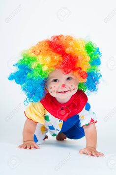 a baby wearing a clown wig and smiling at the camera stock photo - 787982