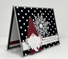 a christmas card with a gnome and snowflakes on the front, in black and white