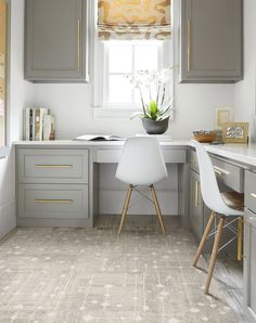 a kitchen with gray cabinets and white counter tops