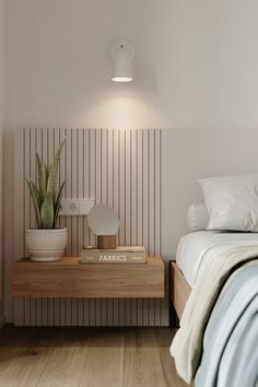 a bed room with a neatly made bed and a plant on the nightstand next to it