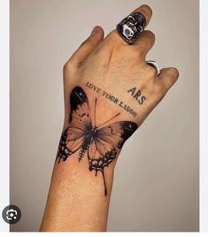 a person's hand with a butterfly tattoo on it and the word arts written in black ink