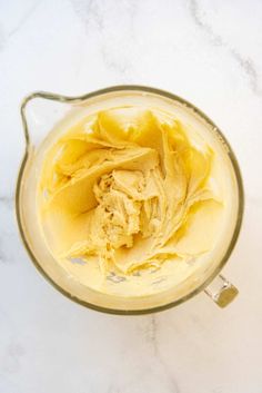 a blender filled with yellow liquid on top of a white counter