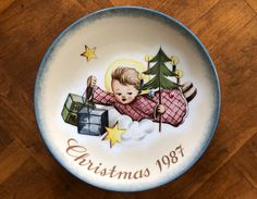 a bowl with a baby on it that says christmas 1897 and presents are in the background