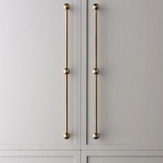 an image of a door handle on the side of a white cabinet with gold handles