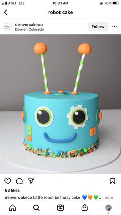 a blue cake with two green and orange sticks sticking out of it's face