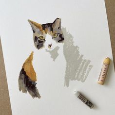 a drawing of a cat next to some crayons