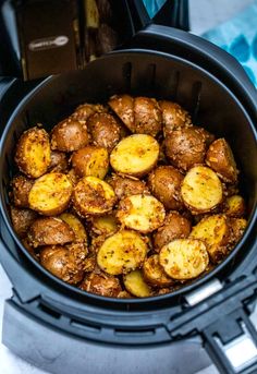 cooked potatoes in an air fryer with seasoning on the top and some other ingredients inside