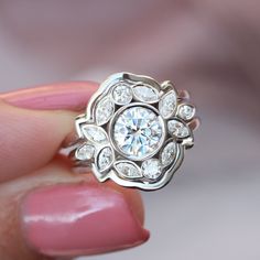 a close up of a person holding a ring with diamonds on the top and bottom