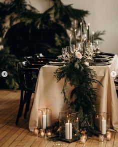 the table is set with candles and greenery