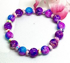 Elevate your style with our Handmade Fashion Glass Bead Bracelet. This trendy accessory features vibrant turquoise and purple glass beads accented with rubber spacer beads, creating a cute and bright look. Each bracelet is meticulously crafted by hand, ensuring a unique and stylish piece that adds a touch of charm to any outfit. Stand out with this stretchy and versatile bracelet that effortlessly complements your individual style. Glass Bead Bracelet, Turquoise And Purple, Glass Beaded Bracelets, Stretchy Bracelets, Purple Glass, Beaded Stretch Bracelet, Trendy Accessories, Handmade Fashion, Individual Style