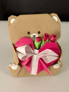 a teddy bear holding a bouquet of roses in it's mouth and wrapped in brown paper