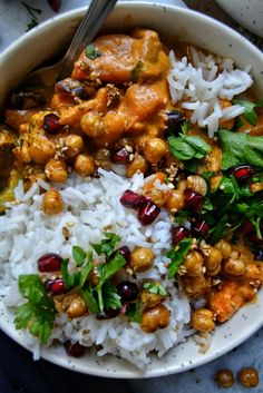 a bowl filled with rice, meat and garnish on top of a table