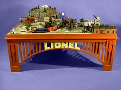 an orange table with a train set on it and a sign that says lione