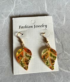 Experience the beauty of nature with our handmade resin dangle earrings. Each pair is carefully crafted with autumn leaves, capturing the essence of the fall season. The intricate gold and green design, accented with delicate gold flakes, adds a touch of elegance and sophistication to any outfit. These unique earrings are a perfect accessory to embrace the beauty of autumn and showcase your individual style. Fall Resin Earrings, Resin Christmas Earrings, Autumn Earrings, Glitter Flake, Gold And Green, Fall Leaf, Fall Earrings, Gold Flakes, Christmas 2024