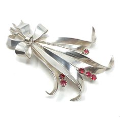 This pretty brooch dates from the 1940s. It's a delightful example of French silver.  Condition Report: Excellent The Details... This brooch is constructed from silver. It features a posy design and is detailed with small, round, claw set, ruby paste stones. The brooch fastens with a trombone clasp and the fastening pin is fitted to the brooch with a round hinge. The brooch measures 7cm x 5cm. It features a French silver makers lozenge shaped stamp - inside which are the initials 'LRS' and what Mid-century Silver Brooch For Collectors, Mid-century Silver Brooches For Collectors, Retro Silver Brooch Pin, Silver Retro Brooch Pin, Retro Silver Brooches For Anniversary, Silver Retro Brooches For Anniversary, Vintage Silver Pins For Anniversary, Mid-century Silver Jewelry With Brooch, Silver Retro Brooches For Gift