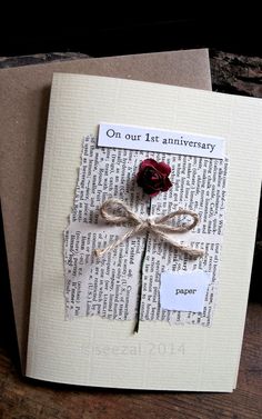 a piece of paper with a rose attached to it on top of a wooden table