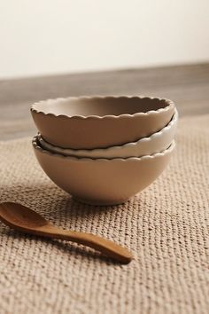 three bowls and a wooden spoon on the floor