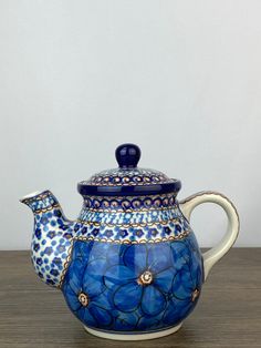 a blue and white teapot sitting on top of a wooden table