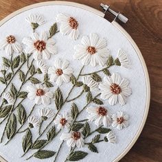 the embroidery is being worked on with white flowers