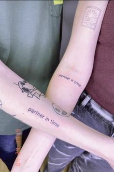 two people with tattoos on their arms holding onto each other's arms and the words partners in time written on them