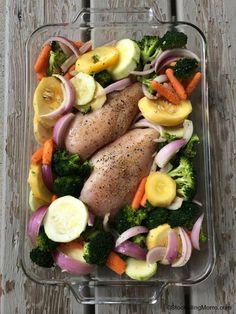 chicken, broccoli, onions, and carrots in a glass dish on a wooden table