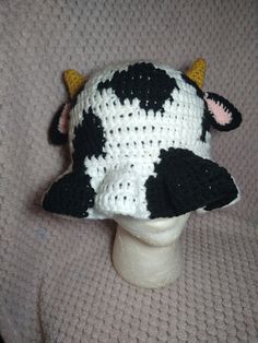 a knitted cow hat sitting on top of a mannequin head