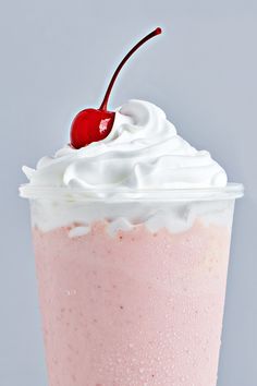 a pink drink with whipped cream and a cherry on top