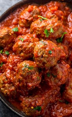 meatballs covered in marinara sauce and garnished with parsley