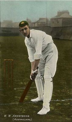 an old photo of a man holding a cricket bat and wearing white pants, standing next to a ball