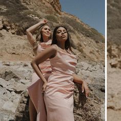 two women in pink dresses standing next to each other on rocks and sand, one woman is holding her hand up