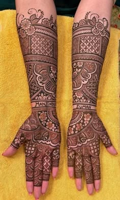 two hands with henna tattoos on them, one is showing off the intricate design