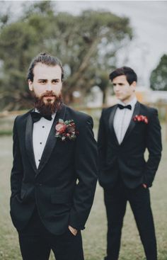 two men in tuxedos standing next to each other on a grass covered field