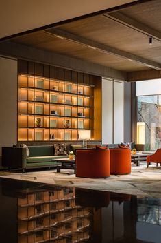 a living room filled with furniture next to a large window covered in bookshelves