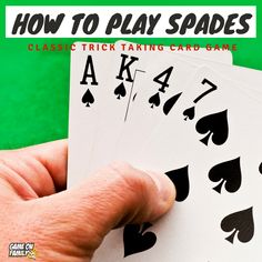 a hand holding four playing cards with the words how to play spades