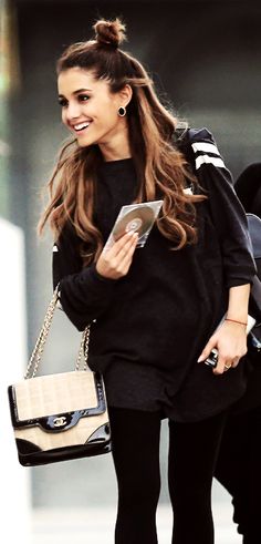 a woman walking down the street while holding a tablet