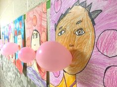 there are pink balloons hanging from the wall next to pictures on the wall with children's drawings