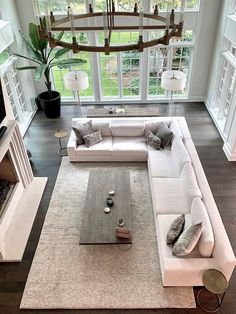 an aerial view of a living room with white couches and coffee table in the center