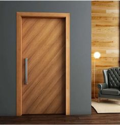 an open wooden door in a living room next to a gray chair and white rug